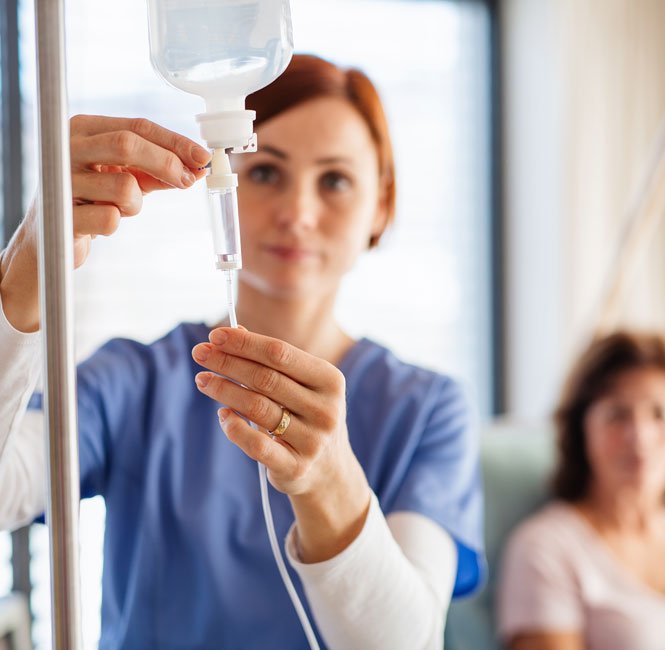 nurse checking the intravenous solution before giving a IV hydration treatment